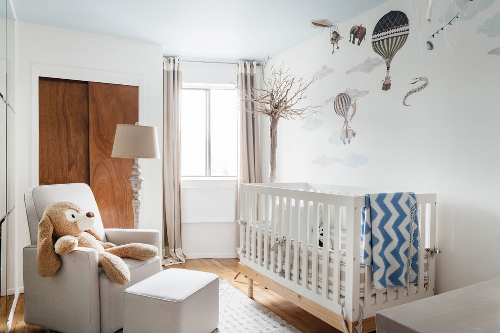 Medium sized classic nursery in New York with white walls, light hardwood flooring and brown floors.