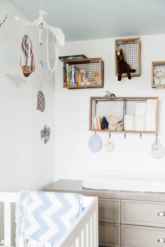 Esempio di una cameretta per neonati chic di medie dimensioni con pareti bianche, pavimento in legno massello medio e pavimento marrone