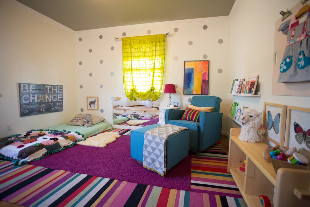 Cette image montre une grande chambre de bébé fille bohème avec un mur beige, un sol en bois brun et un sol multicolore.