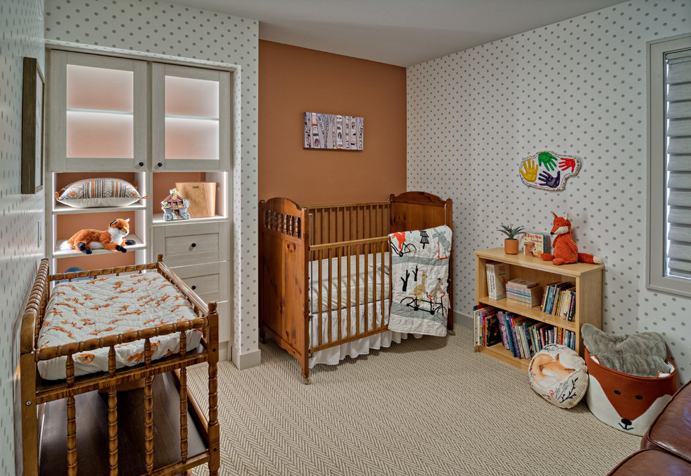 Modern inredning av ett litet könsneutralt babyrum, med orange väggar, heltäckningsmatta och beiget golv