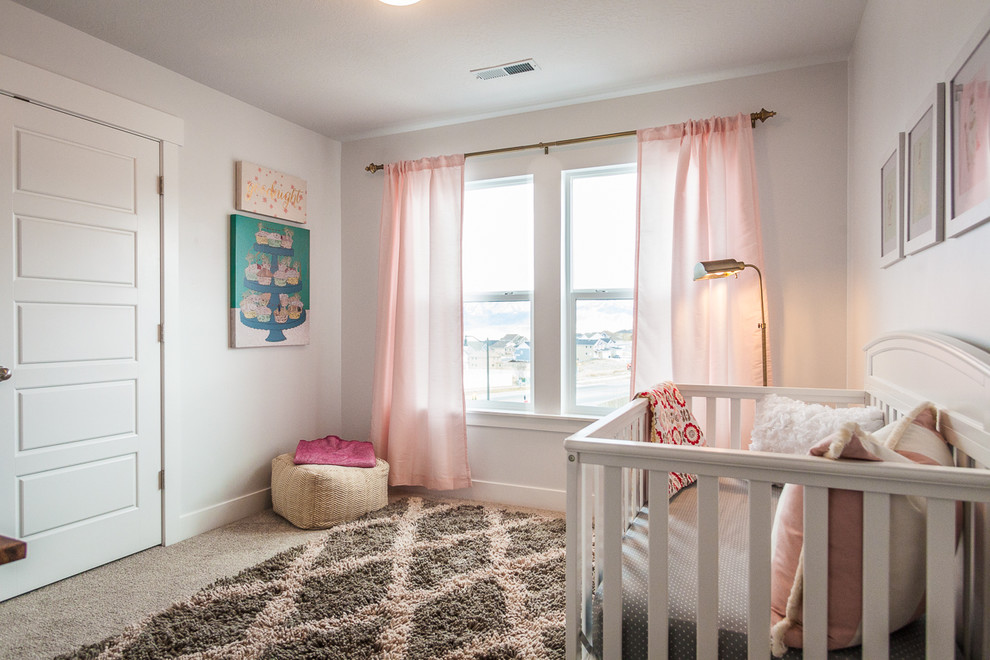 Imagen de habitación de bebé niña tradicional renovada grande con paredes blancas, moqueta y suelo marrón