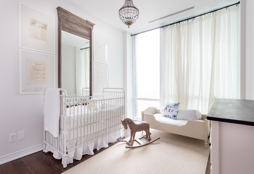 Large traditional nursery for girls in Toronto with white walls, dark hardwood flooring and brown floors.