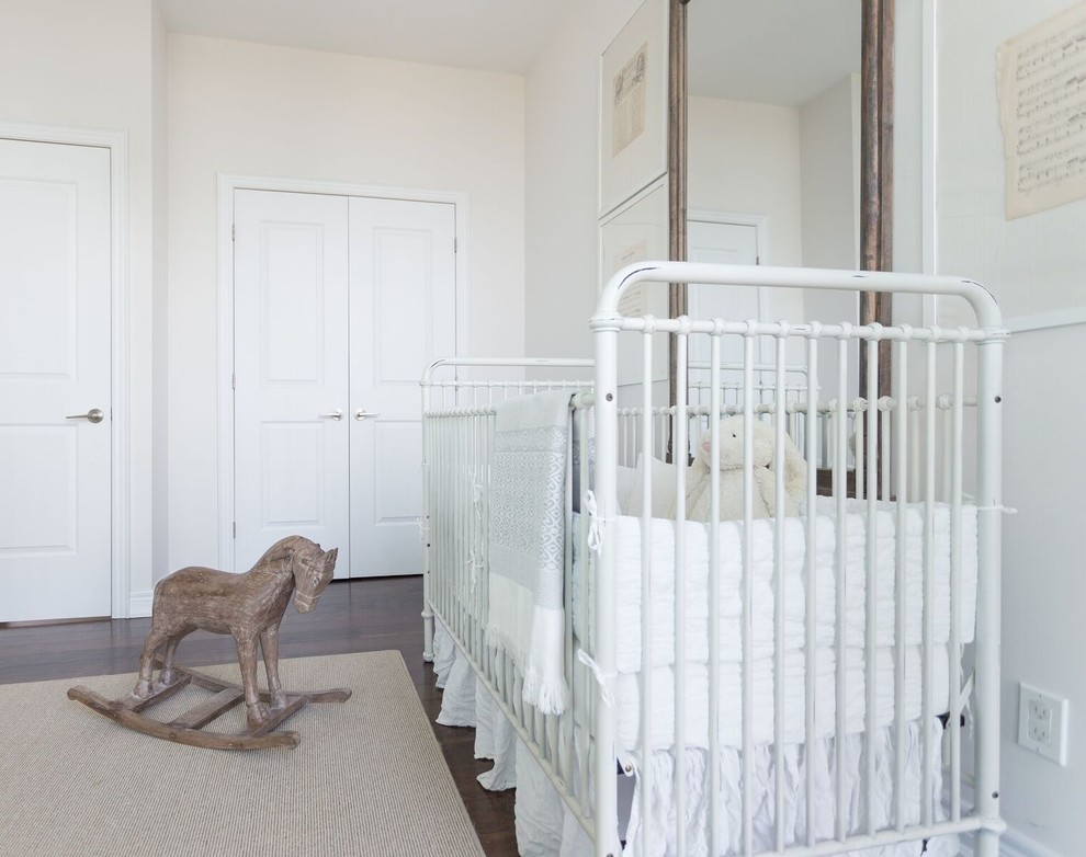 Ejemplo de habitación de bebé niña clásica renovada grande con paredes blancas, suelo de madera oscura y suelo marrón
