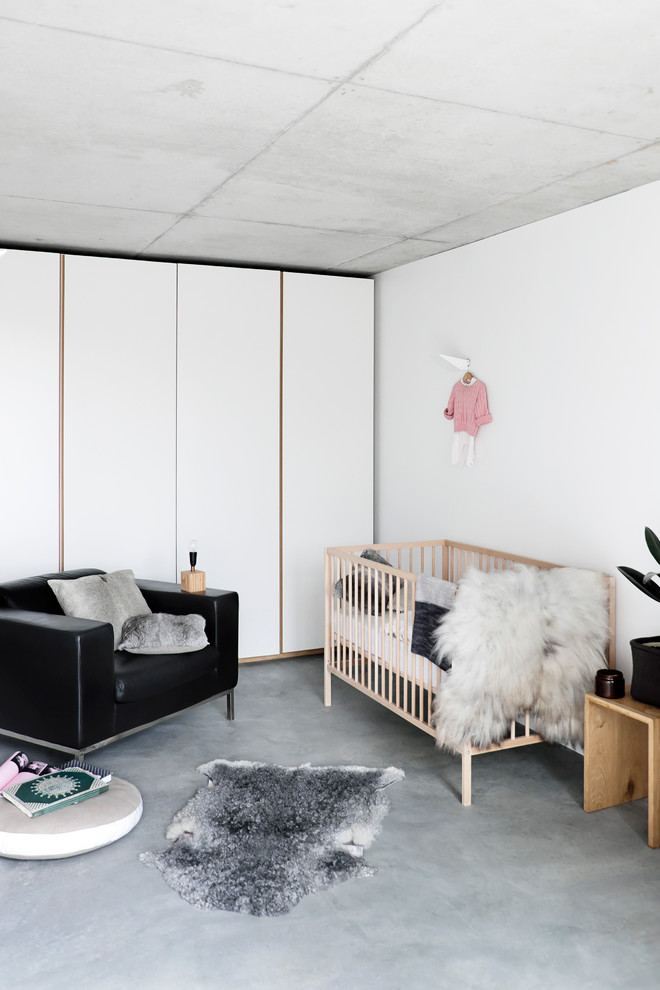 Aménagement d'une chambre de bébé neutre moderne avec un sol gris.