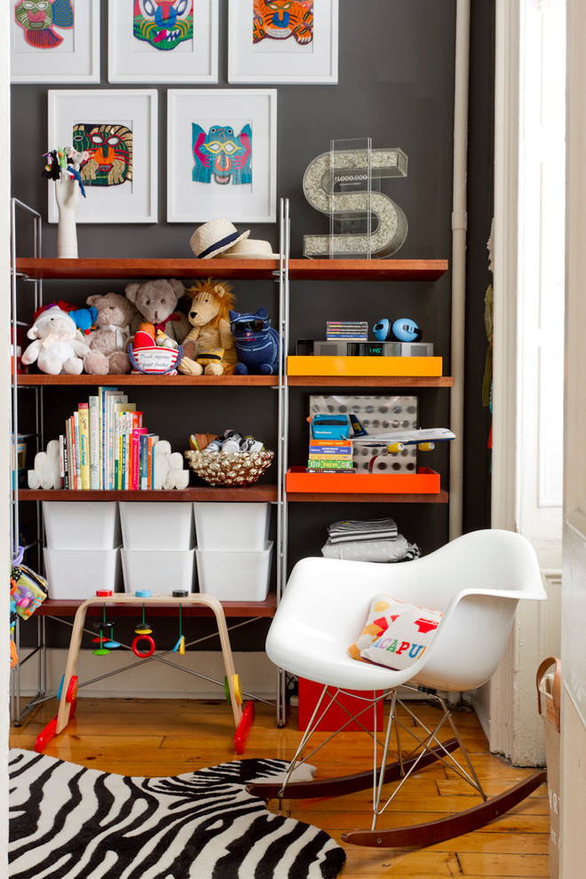 Aménagement d'une chambre de bébé neutre éclectique avec un mur noir, un sol en bois brun et un sol orange.