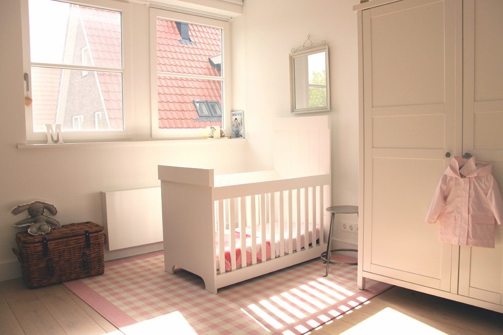 Idées déco pour une chambre de bébé neutre classique avec un mur blanc et parquet clair.
