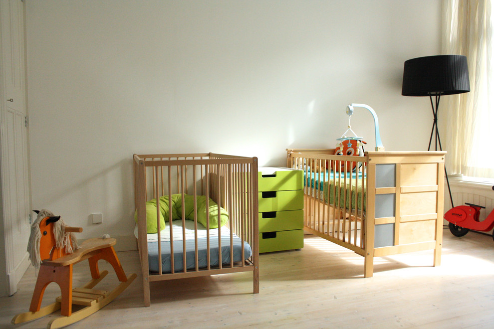 Immagine di una cameretta per neonati scandinava con pareti bianche