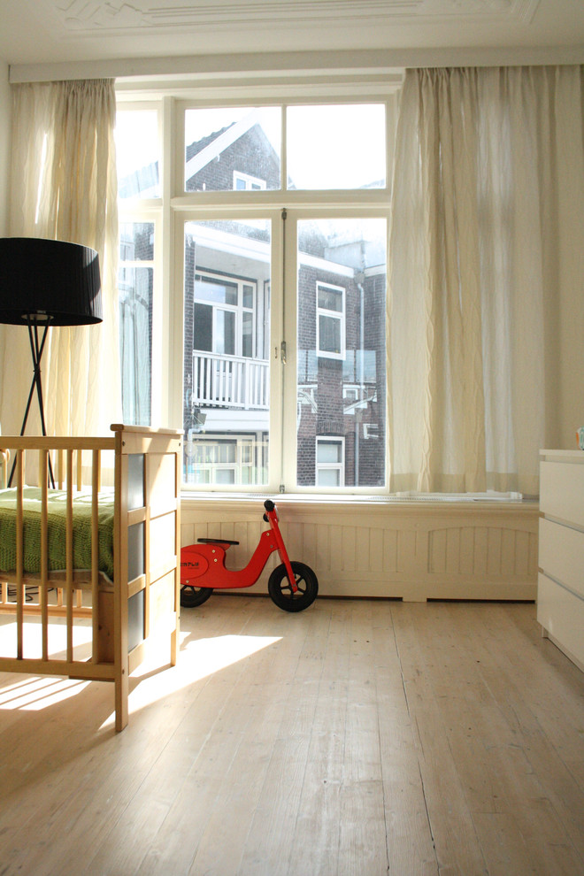 На фото: нейтральная комната для малыша в стиле неоклассика (современная классика) с светлым паркетным полом с