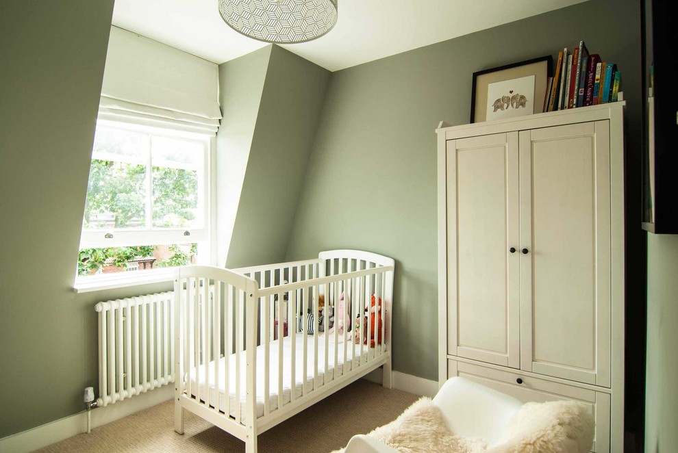 Photo of a modern gender neutral nursery in London with green walls and carpet.