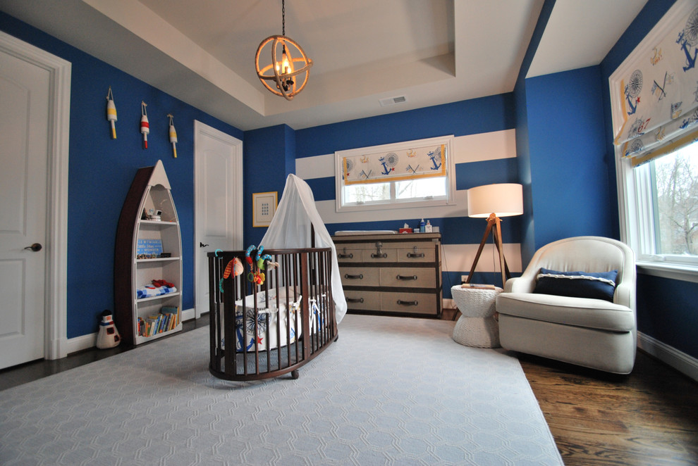 Aménagement d'une chambre de bébé garçon bord de mer de taille moyenne avec un mur bleu, un sol en bois brun et un sol marron.