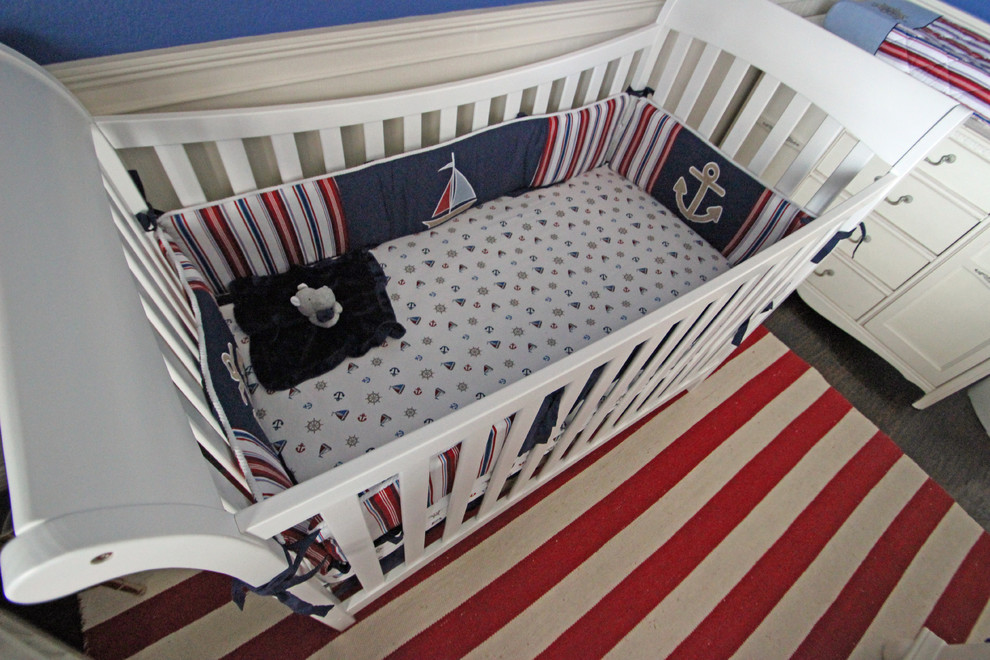 Réalisation d'une chambre de bébé garçon tradition de taille moyenne avec un mur bleu et un sol en bois brun.