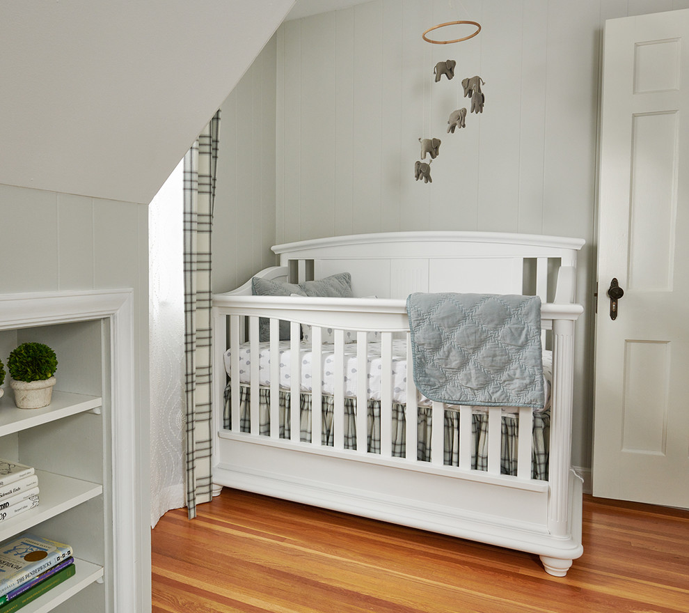 Imagen de habitación de bebé niño tradicional renovada pequeña con paredes grises y suelo de madera en tonos medios