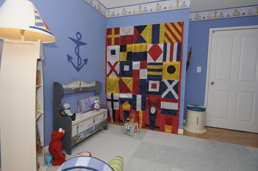 Diseño de habitación de bebé niño bohemia de tamaño medio con paredes azules y suelo de madera en tonos medios