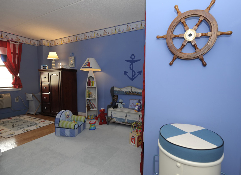 Esempio di una cameretta per neonato boho chic di medie dimensioni con pareti blu e pavimento in legno massello medio