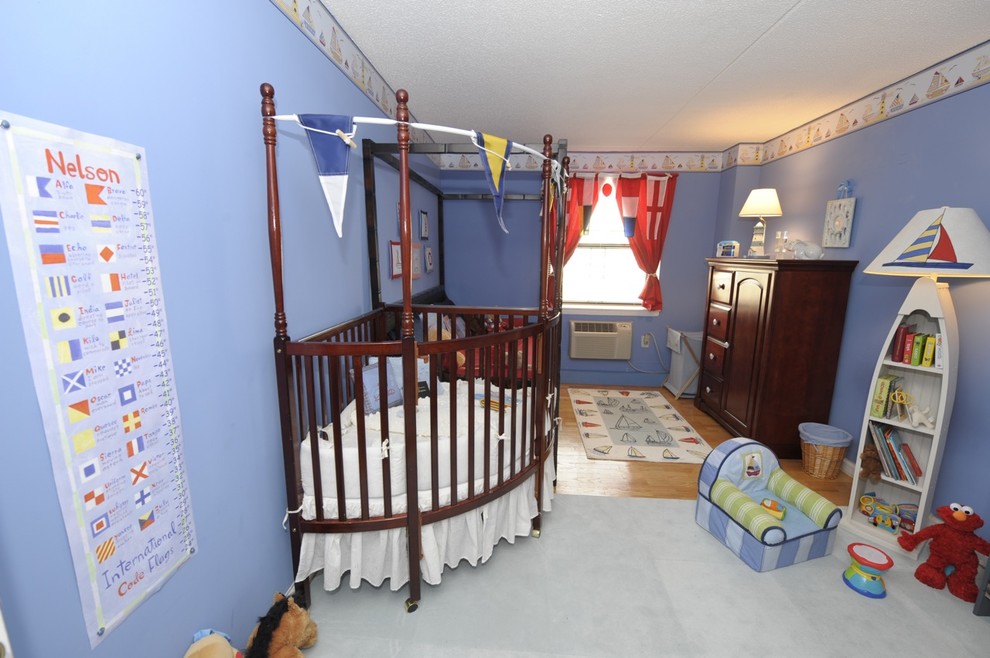 Cette image montre une chambre de bébé garçon bohème de taille moyenne avec un mur bleu et un sol en bois brun.