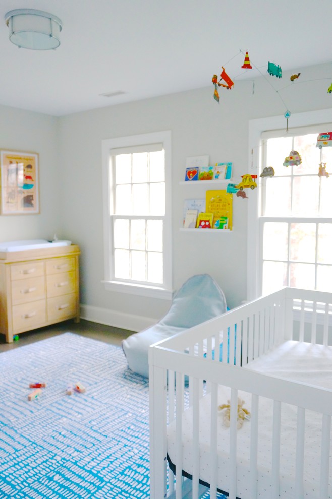 Mittelgroßes Klassisches Babyzimmer mit dunklem Holzboden, grauer Wandfarbe und braunem Boden in New York