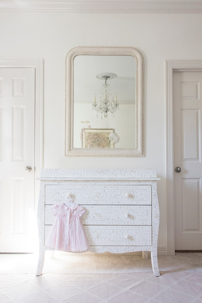 Ejemplo de habitación de bebé niña clásica renovada pequeña con paredes blancas y moqueta