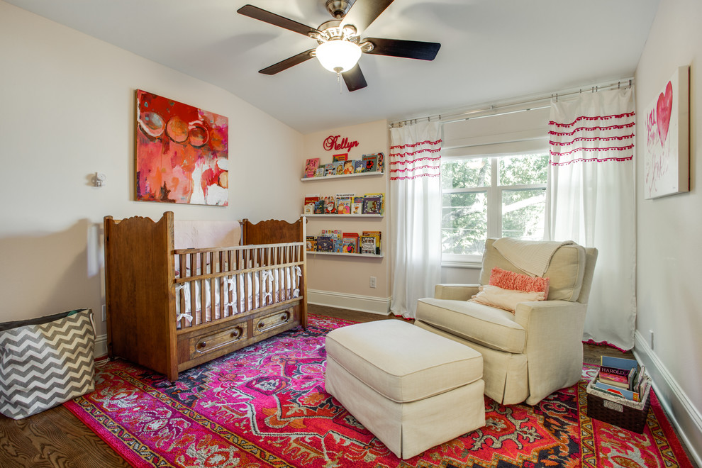 Ejemplo de habitación de bebé niña tradicional de tamaño medio con paredes beige y suelo de madera oscura