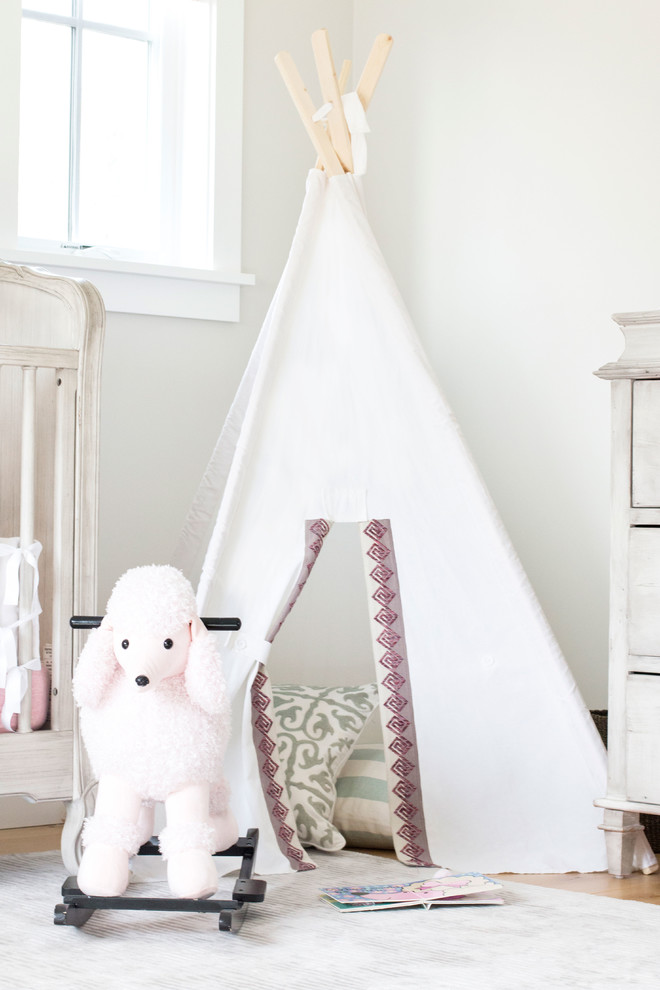 Idéer för ett mellanstort minimalistiskt babyrum, med beige väggar och ljust trägolv