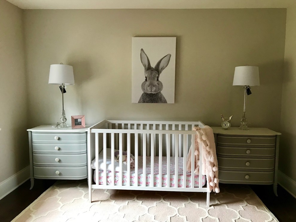 Esempio di un'ampia cameretta per neonata chic con pareti beige, pavimento in legno massello medio, pavimento marrone e soffitto a cassettoni