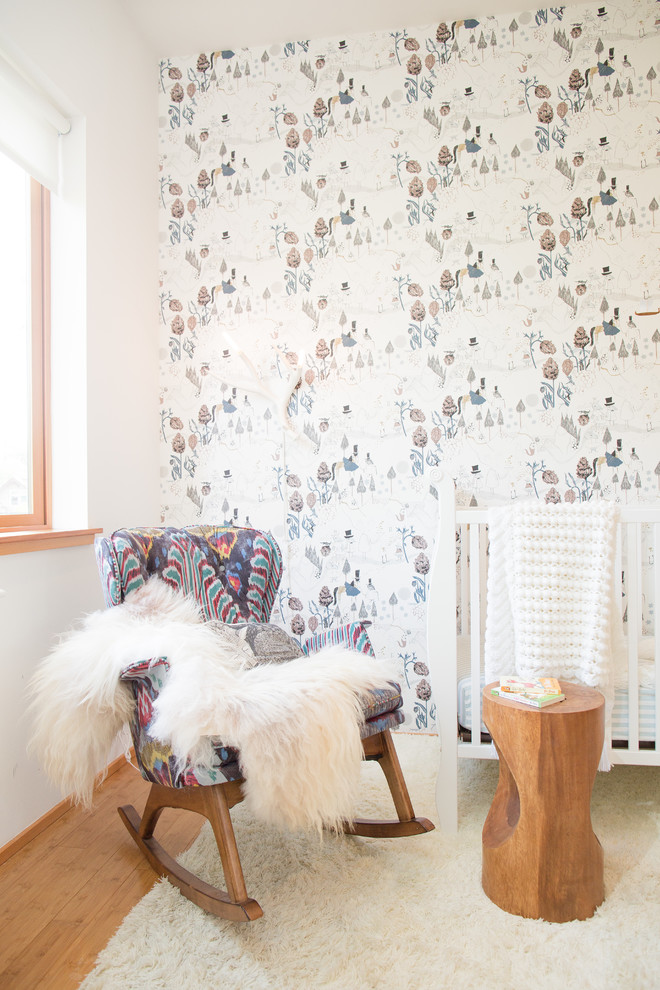 На фото: маленькая нейтральная комната для малыша в скандинавском стиле с белыми стенами, полом из бамбука и бежевым полом для на участке и в саду