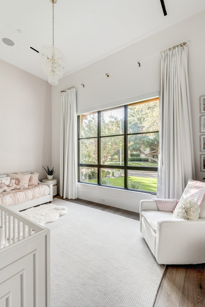 Klassisches Babyzimmer mit weißer Wandfarbe, braunem Holzboden und braunem Boden in Dallas
