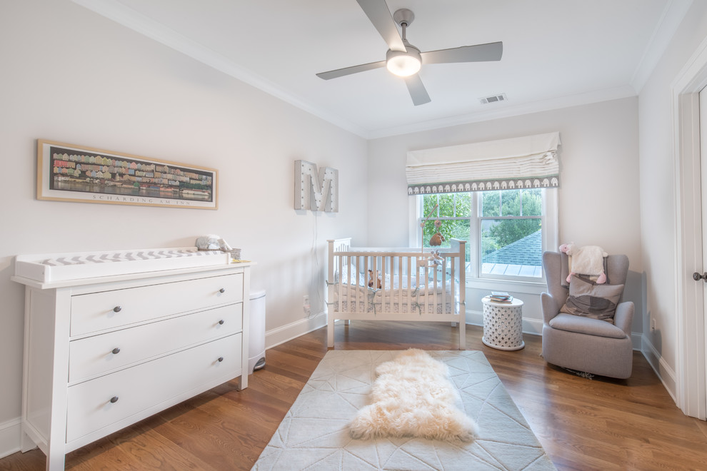 Idées déco pour une chambre de bébé neutre classique avec un mur gris, un sol en bois brun et un sol marron.