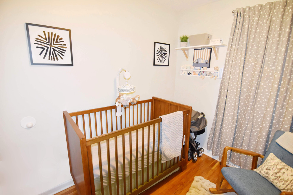 Idée de décoration pour une petite chambre de bébé garçon vintage avec un mur gris, parquet clair et un sol marron.