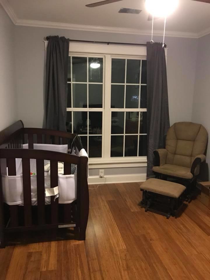 Exemple d'une petite chambre de bébé garçon chic avec un mur gris, parquet en bambou et un sol marron.