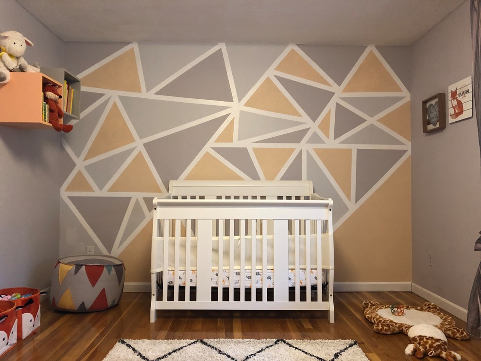 Esempio di una cameretta per neonato moderna di medie dimensioni con pareti multicolore e parquet chiaro