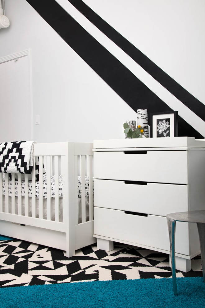 Design ideas for a small contemporary nursery for boys in Chicago with grey walls and light hardwood flooring.