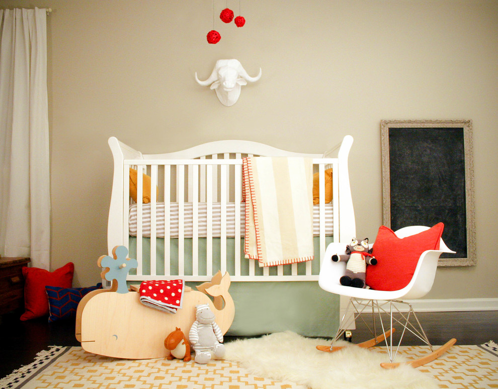 This is an example of a small scandi gender neutral nursery in Atlanta with grey walls and dark hardwood flooring.