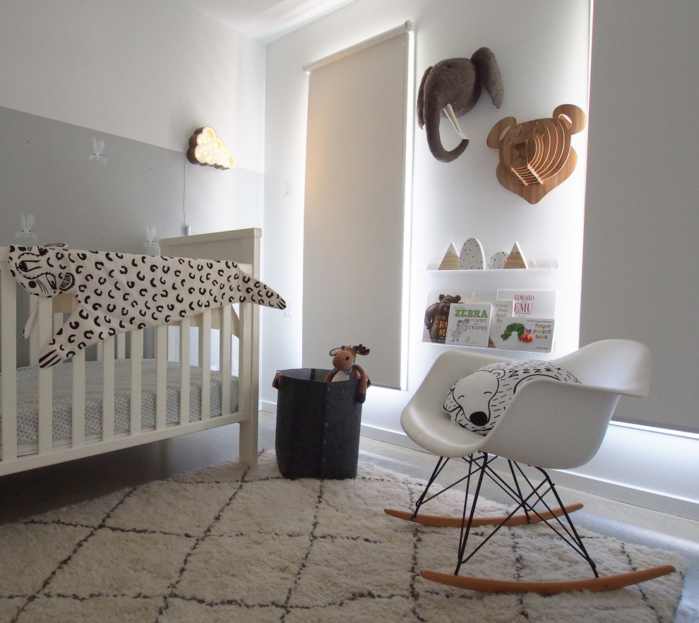 Пример оригинального дизайна: комната для малыша среднего размера в современном стиле с белыми стенами и бетонным полом