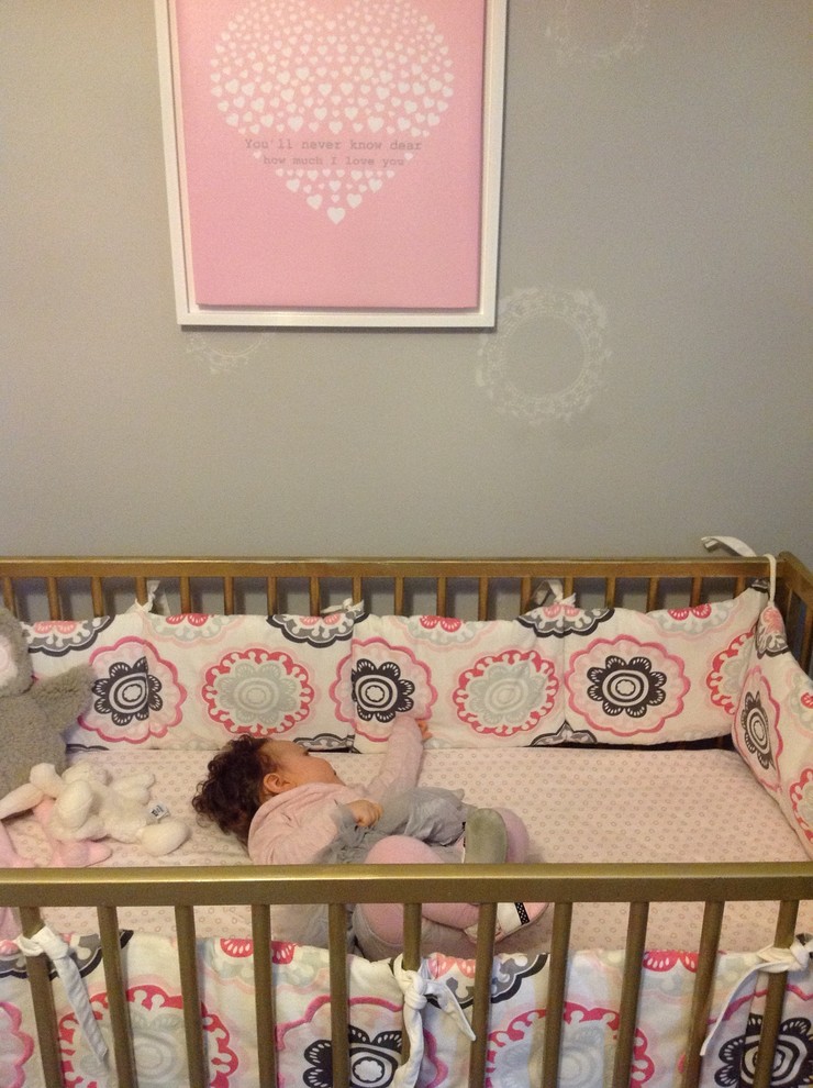 Small traditional nursery for girls in Toronto with grey walls and laminate floors.