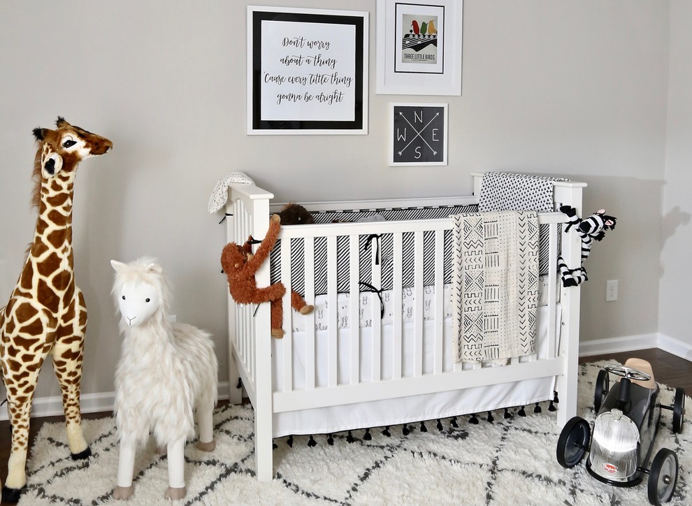 Modelo de habitación de bebé neutra minimalista con paredes grises, suelo de madera oscura y suelo marrón