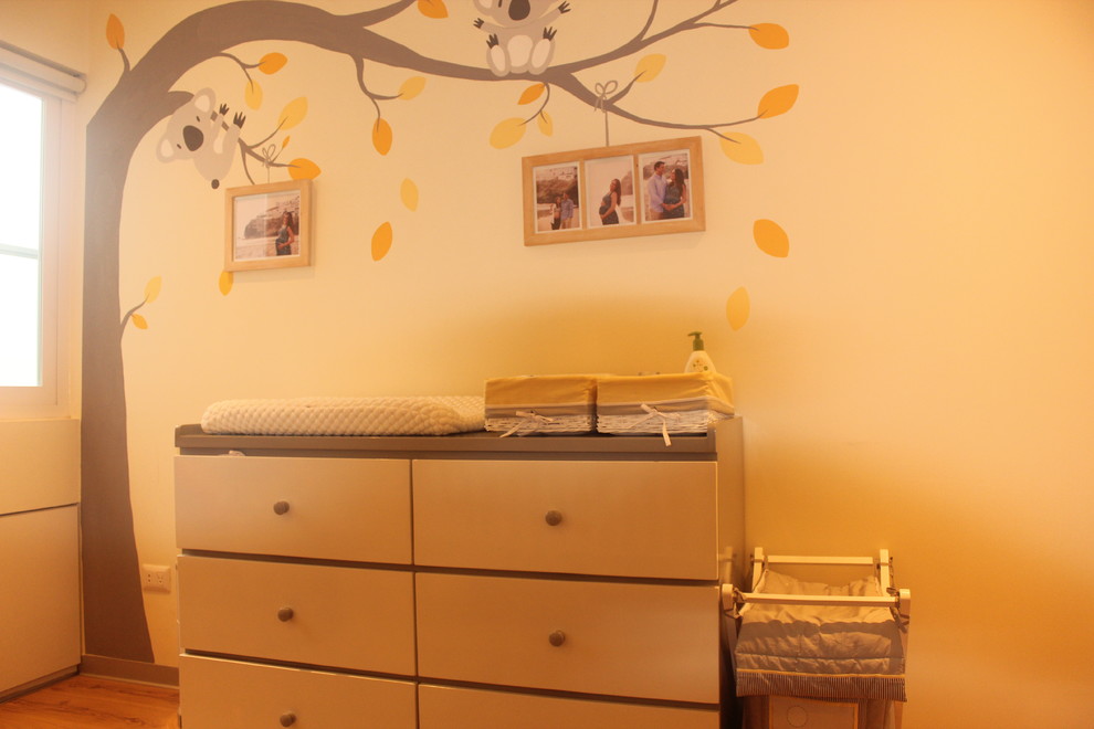 На фото: большая нейтральная комната для малыша в стиле неоклассика (современная классика) с желтыми стенами, паркетным полом среднего тона и коричневым полом с