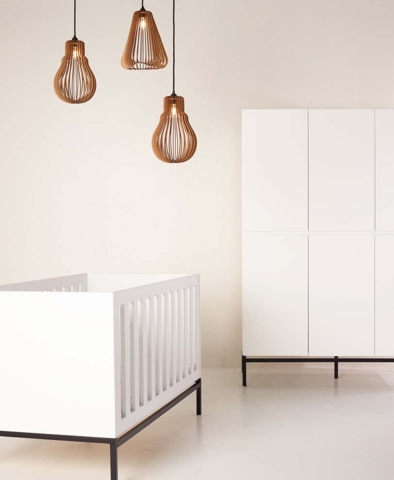 Cette photo montre une chambre de bébé neutre tendance de taille moyenne avec un mur blanc, sol en béton ciré et un sol gris.
