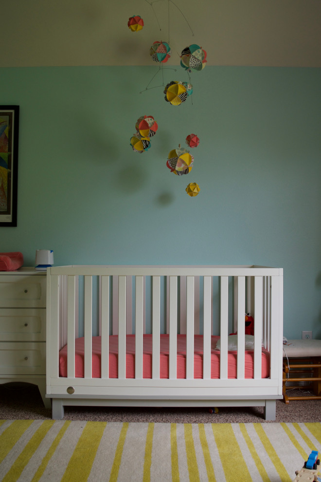 This is an example of an eclectic nursery for girls in Other with blue walls.