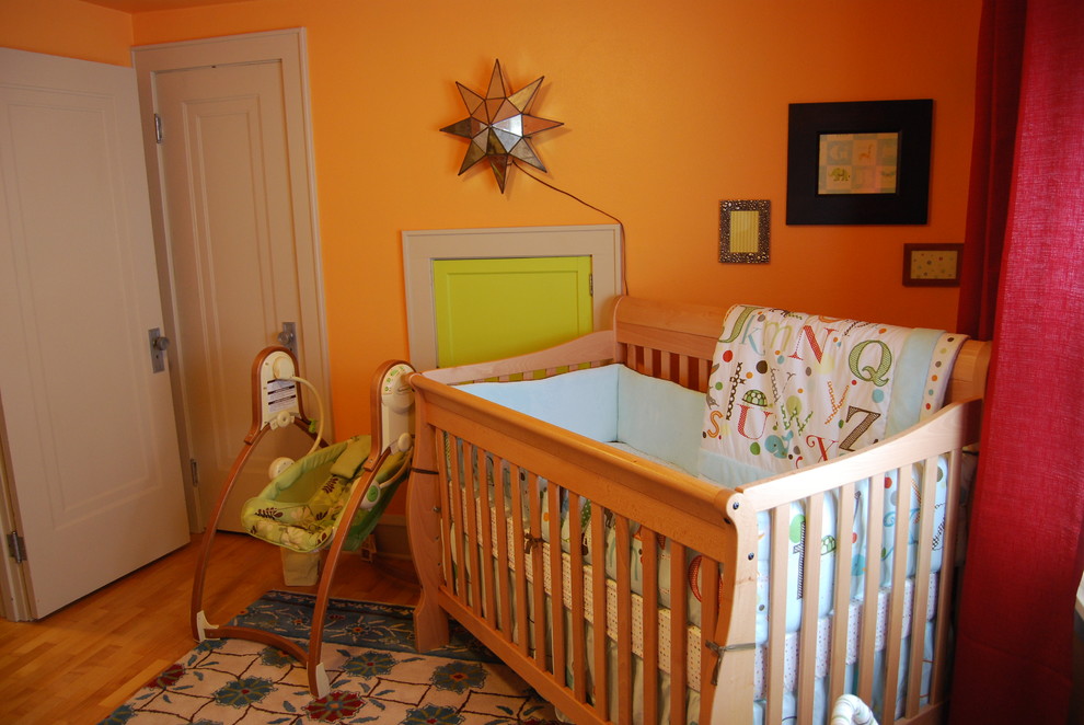 Идея дизайна: нейтральная комната для малыша в классическом стиле с оранжевыми стенами и паркетным полом среднего тона