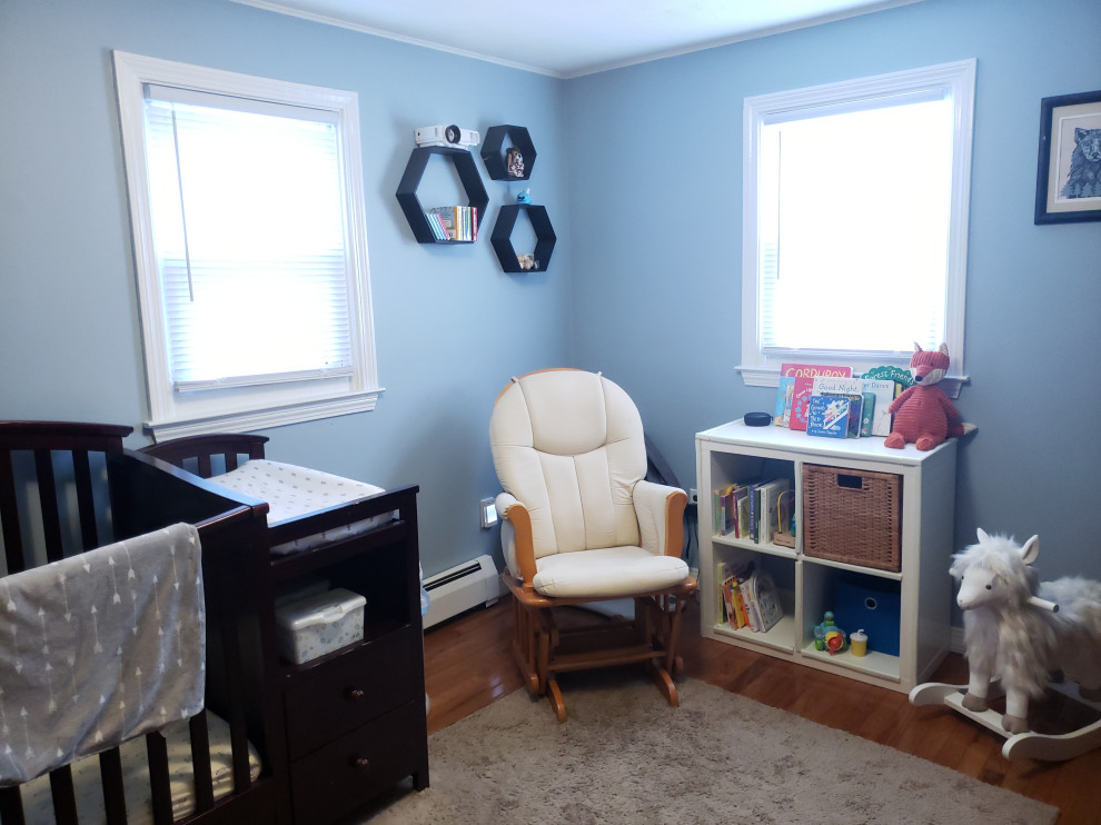 Modelo de habitación de bebé niño campestre pequeña con paredes azules y suelo de madera en tonos medios
