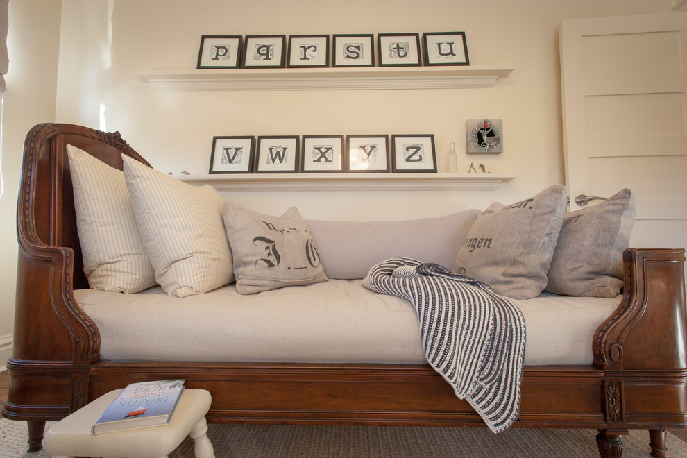 Diseño de habitación de bebé neutra de estilo americano con paredes beige y suelo de madera oscura