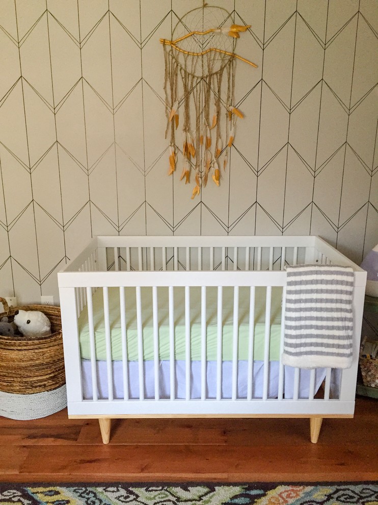 Aménagement d'une chambre de bébé neutre rétro de taille moyenne avec un mur gris et un sol en bois brun.