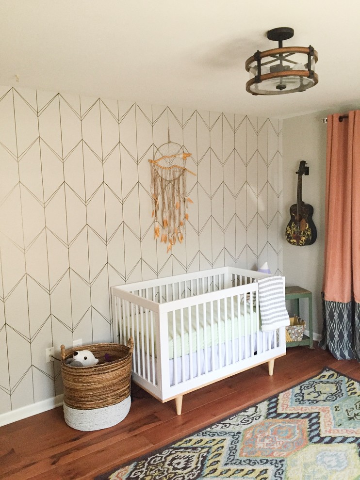 Modelo de habitación de bebé neutra retro de tamaño medio con paredes grises y suelo de madera en tonos medios