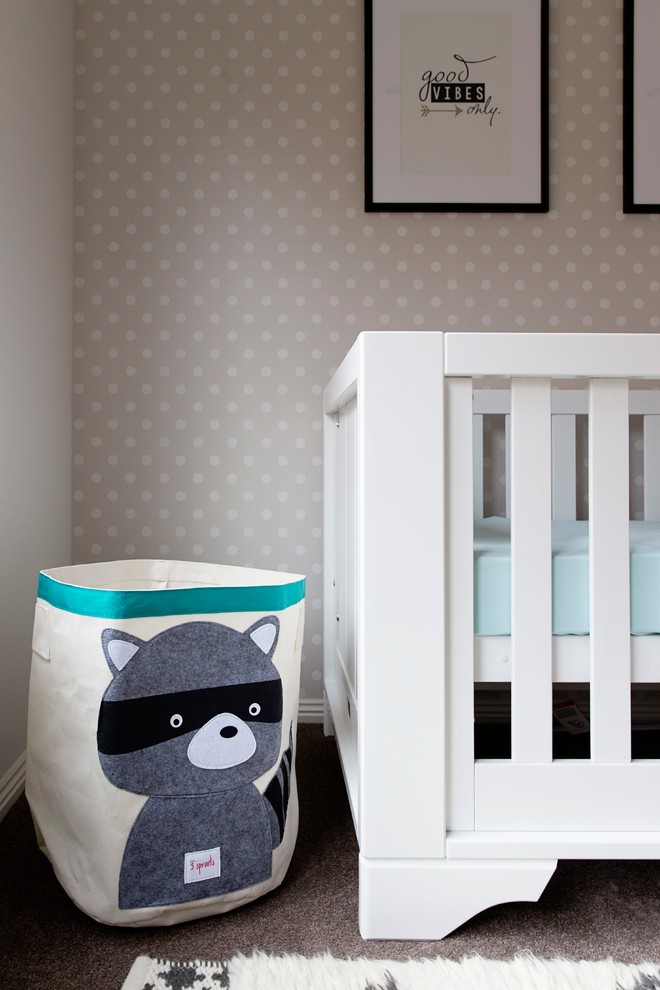 Imagen de habitación de bebé neutra actual pequeña con paredes beige y moqueta