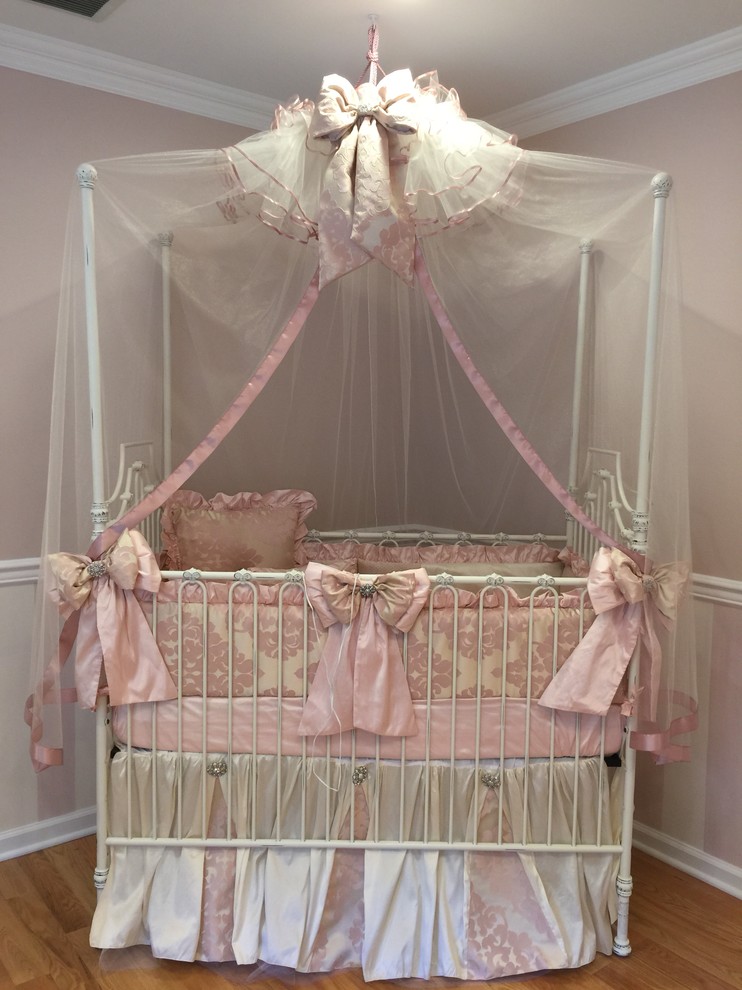 Пример оригинального дизайна: большая комната для малыша в классическом стиле с розовыми стенами и светлым паркетным полом для девочки