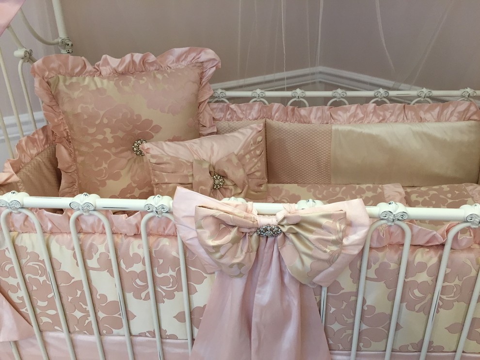 Esempio di una grande cameretta per neonata tradizionale con pareti rosa e parquet chiaro
