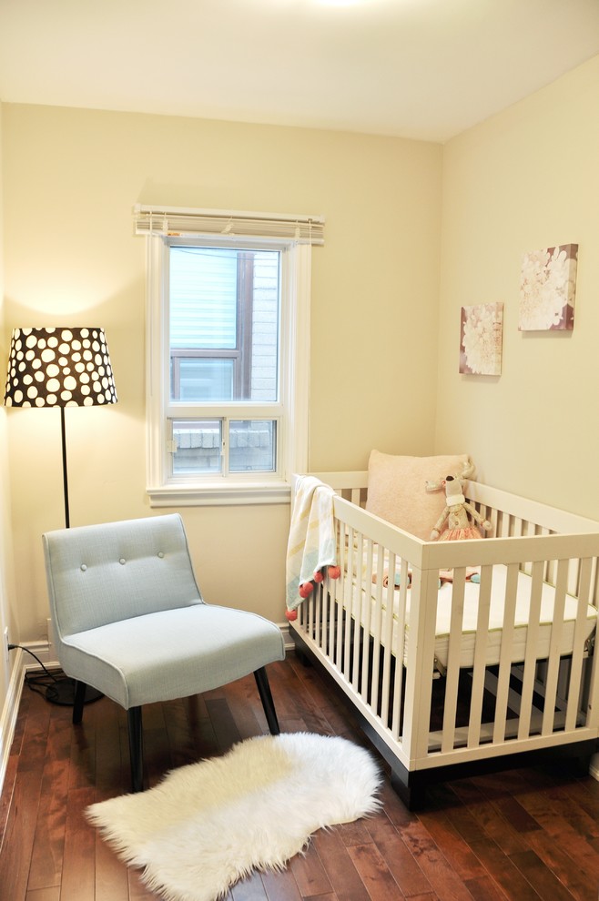 トロントにある低価格の小さなコンテンポラリースタイルのおしゃれな赤ちゃん部屋 (ベージュの壁、濃色無垢フローリング、男女兼用) の写真