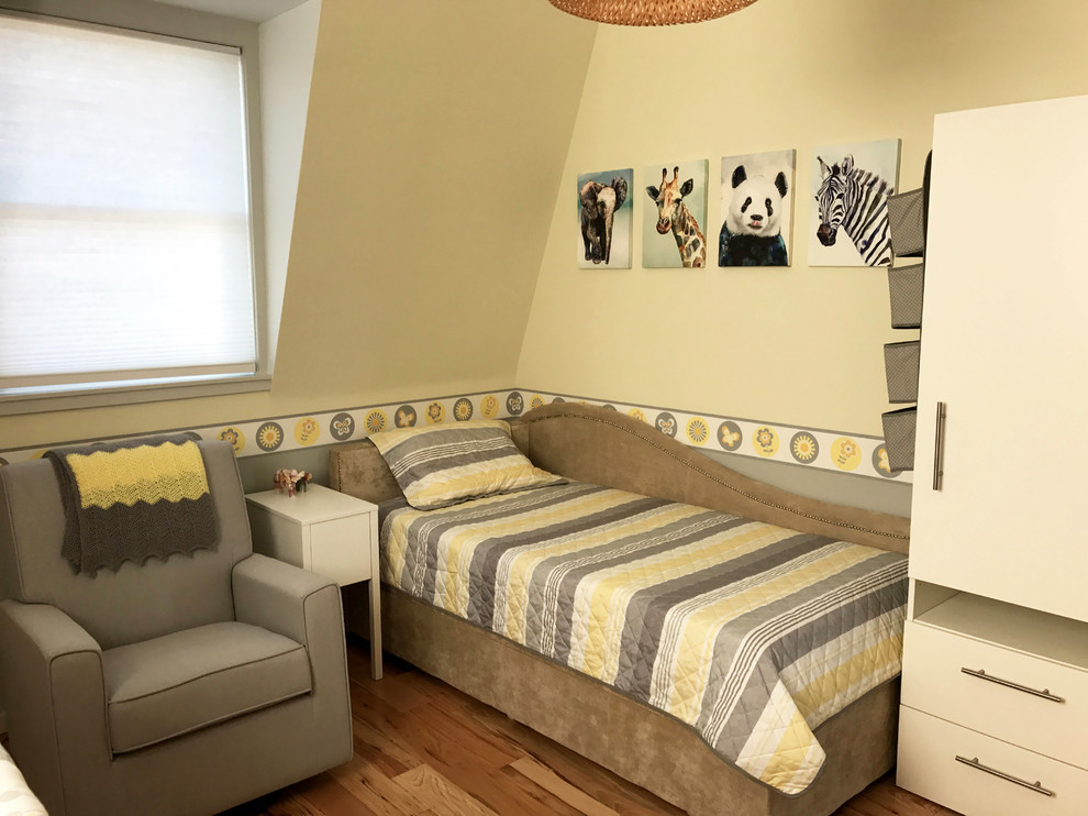 Réalisation d'une chambre de bébé neutre minimaliste de taille moyenne avec un mur jaune et parquet clair.