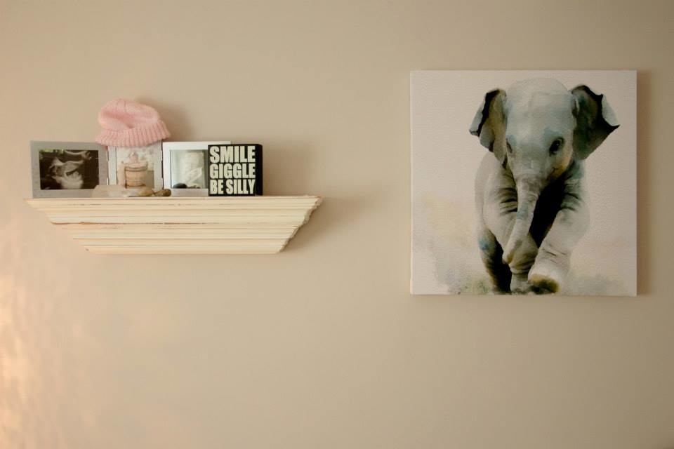 Modelo de habitación de bebé niña rústica de tamaño medio con paredes beige y suelo laminado