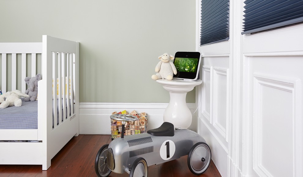 Aménagement d'une chambre de bébé garçon moderne de taille moyenne avec un mur vert et parquet foncé.